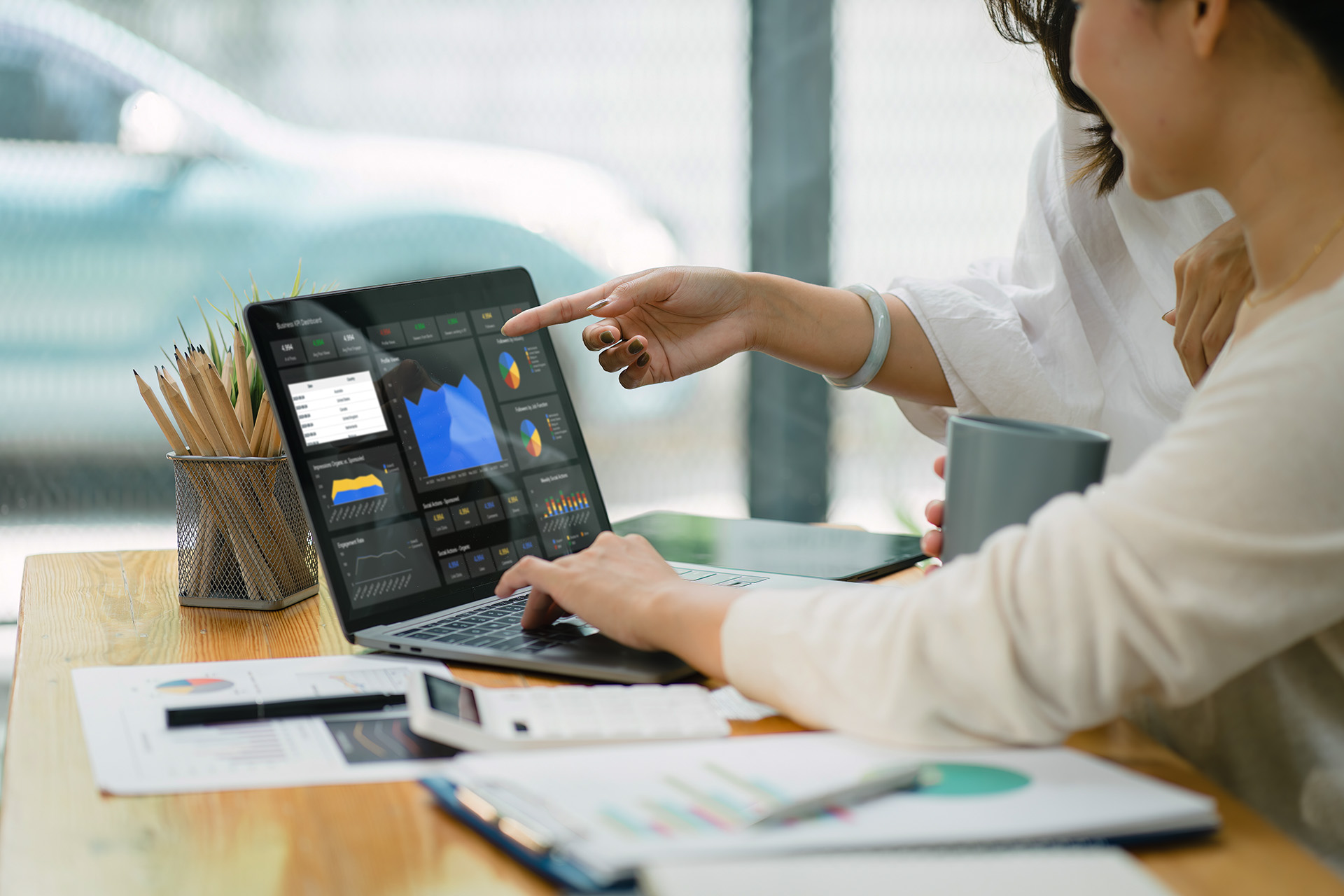 person-using-computer-analytics Businesswoman advisor team are analyzing data charts, graphs, and a dashboard on a laptop screen in order to prepare a statistical report and discuss financial data in an office.